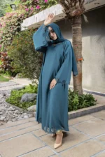 Heba Cutwork Abaya by Alsanaya – Pine green Nidah fabric with cutwork and stone embellishments, includes matching chiffon scarf